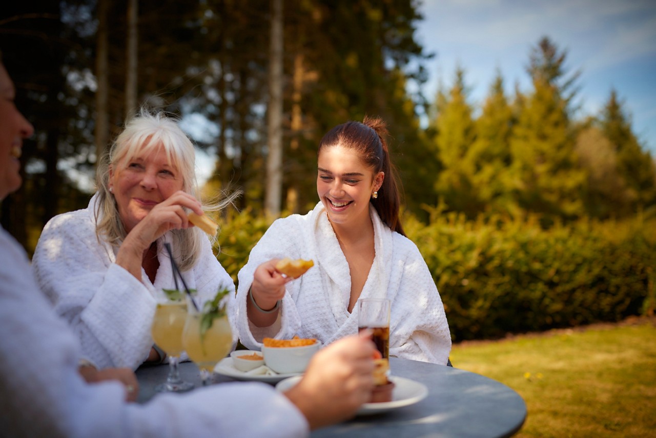 Mum and daughter outside eating.